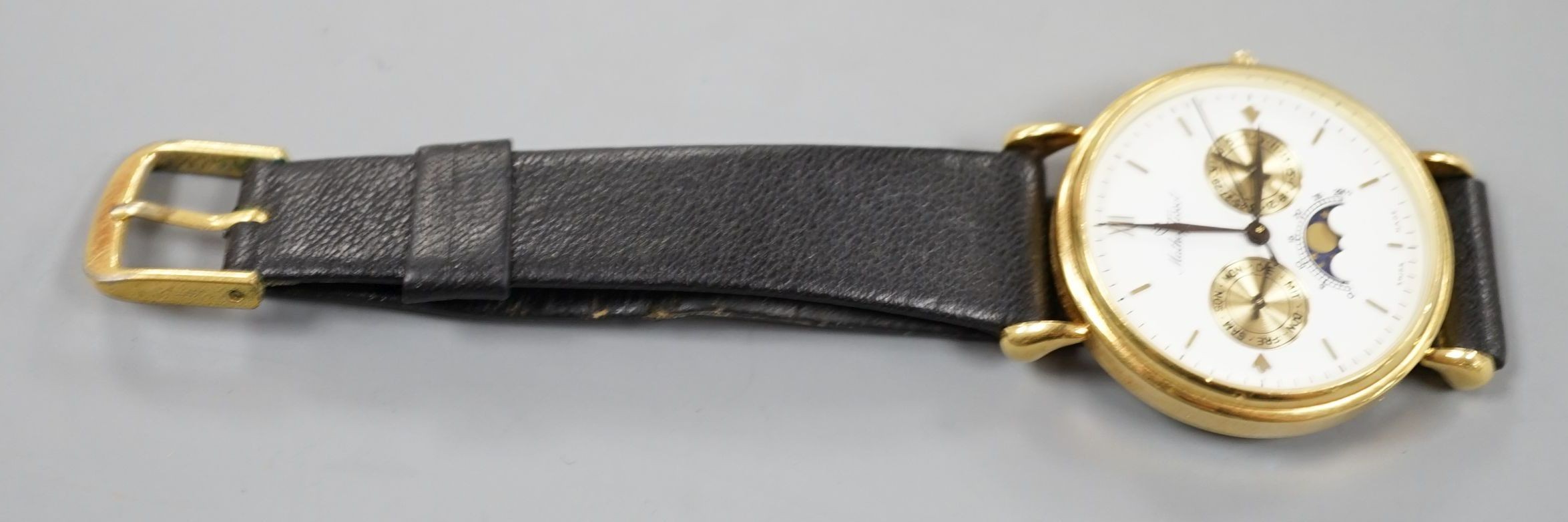 A modern 18k Mathey-Tissot calendar moonphase quartz wrist watch, on a black leather strap, no box or papers.
